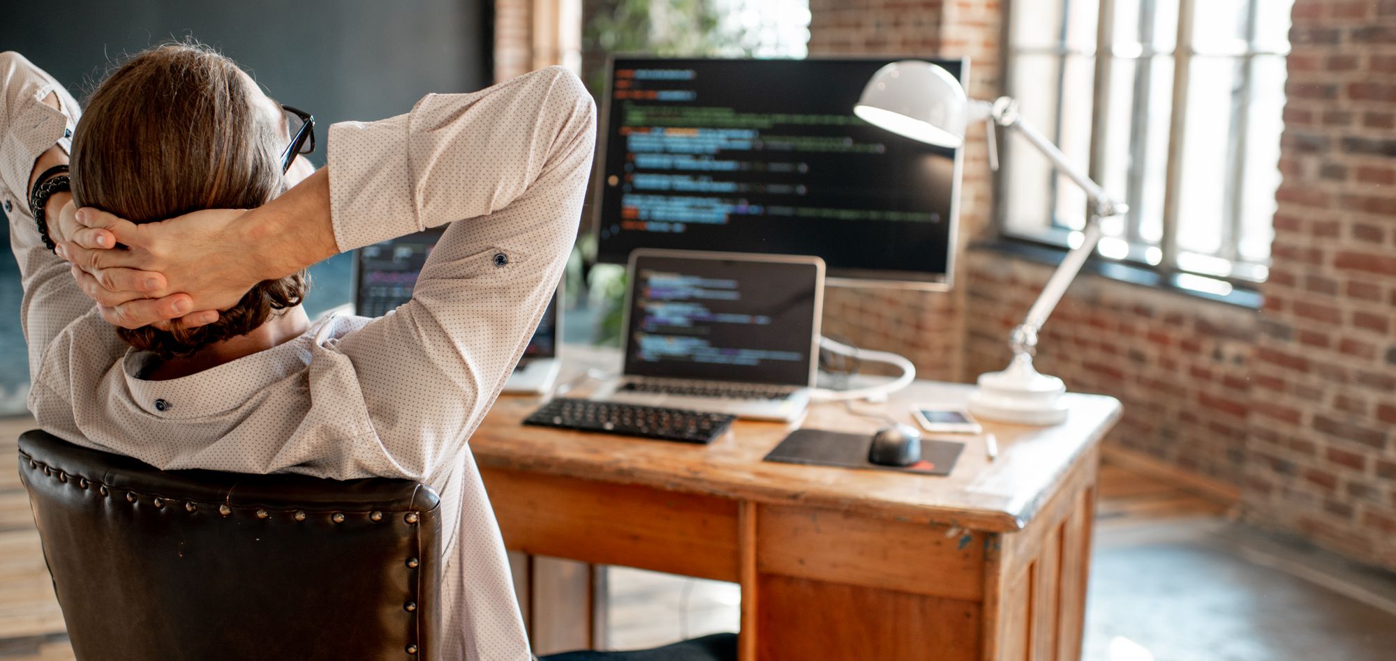 A developer sitting back in his chair, relaxing