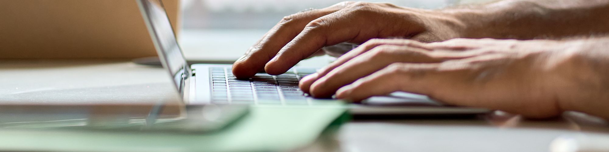 a pair of hands working on a laptop