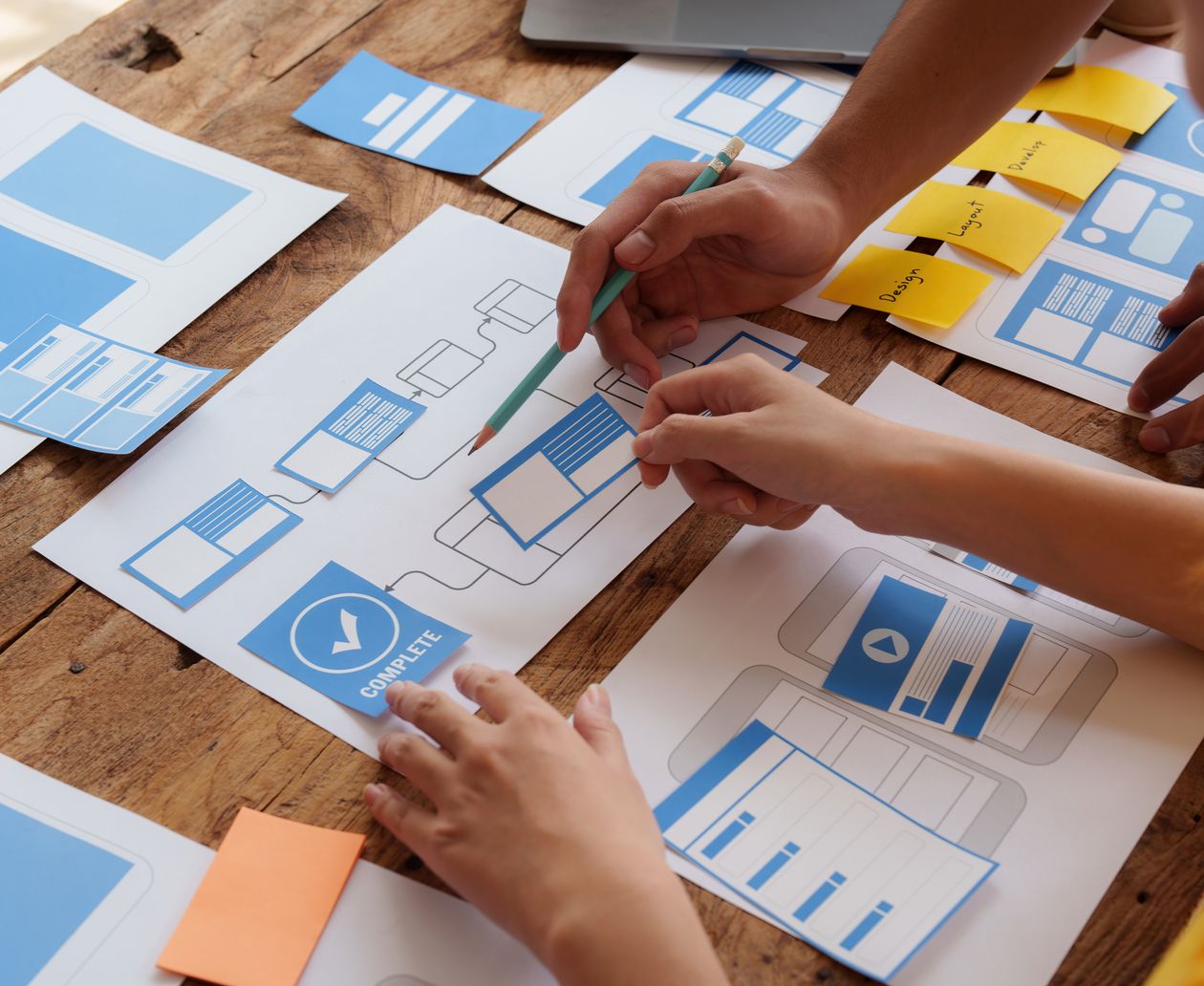 people putting together a website design on a table